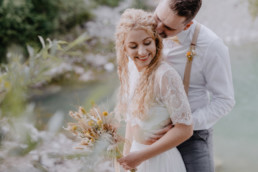 Braut und Bräutigam lachen sich an mit natürlichem Brautstrauß von Ganz Unverblümt