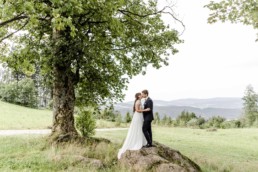 Braut und Bräutigam küssen sich auch Steinen vor Bayerischem Wald