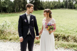 Bräutigam und Braut mit Strauß und Anstecker mit Wiesenblumen von Ganz Unverblümt
