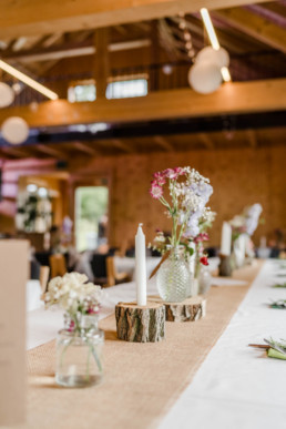 Tischdekoration mit Baumscheiben und Blumenvasen von Ganz Unverblümt Steinach