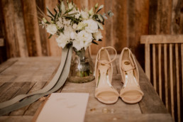 Detailaufnahme der Schuhe und des Brautstraußes von Ganz Unverblümt in Weiß Grün