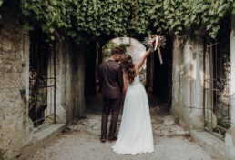 Braut und Bräutigam küssen sich mit Brautstrauß in der Hand von Ganz Unverblümt