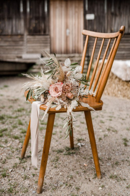 Boho Brautstrauß liegt auf Stuhl