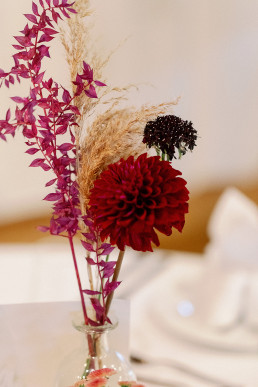 Vase gefüllt mit Beerentönigen Blumen und Trockenblumen von Ganz Unverblümt