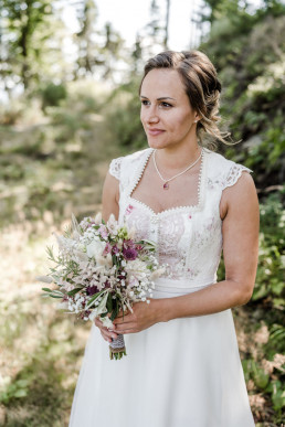 Braut lächelt mit natürlichem Brautstrauß von Ganz Unverblümt
