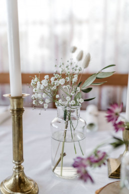 Glasvase mit schlichten Blumen und Gräsern von Ganz Unverblümt