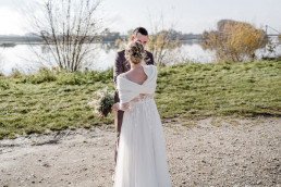 Braut und Bräutigam stehen am Donauufer mit Körperschmuck von Ganz Unverblümt