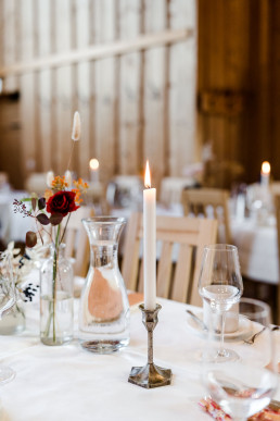 Goldene Kerzenständer und Vase mit bunten Blumen auf Tisch von Ganz Unverblümt