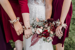 Armbänder der Brautjungfern und Brautstrauß in Weinrot