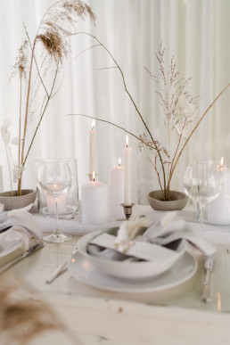 Minimalistische Tischdekoration mit Kerzen Trockenblumen und Schalen von Ganz Unverblümt