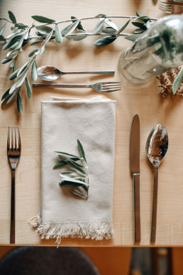 Eingedeckter Tisch mit Olivenzweigen von Ganz Unverblümt