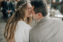 Braut und Bräutigam glücklich mit Blumenkranz von Ganz Unverblümt
