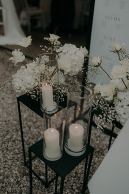 Schwarze Tische mit Windlichtern und weißen Gestecken von Ganz Unverblümt