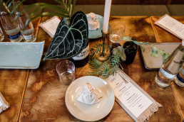 Detailaufnahme Tisch mit grünen Blättern und Kerzenständern von Ganz Unverblümt
