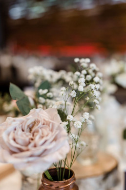 Detailaufnahme Rose und Schleierkraut in Kupfervase