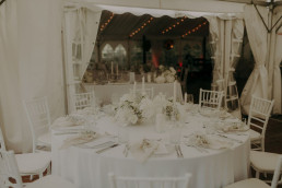 Eingedeckte Tische komplett in Weiß mit Gestecken und Kerzenständern von Ganz Unverblümt