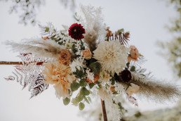 Natürliches Traubogengesteck mit frischen Blumen und Trockenblumen von Ganz Unverblümt