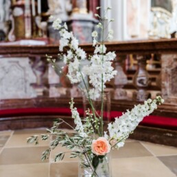 Große Vasen in Kirche mit Rosen Olivenzweigen und Lupine