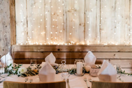 Eingedeckter Tisch mit Girlande aus Olivenzweigen und Blumen von Ganz Unverblümt