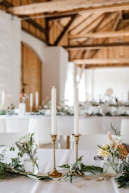 Tischdekoration mit saisonalen Blumen und goldenen Kerzenständern von Hochzeitsflorist Ganz Unverblümt Steinach