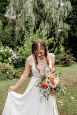 Braut mit herbstfarbenem Brautstrauß von Ganz Unverblümt schwingt ihr Brautkleid