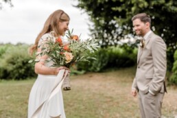 Brautpaar beim First Look mit Brautstrauß in Rost und Natur von Ganz Unverblümt Steinach