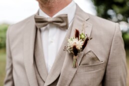 Bräutigam mit Anstecker aus Trockenblumen gestaltet von Hochzeitsflorist Ganz Unverblümt Steinach