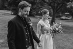 Brautpaar in Tracht mit Wiesenblumen von Ganz Unverblümt am Wildberghof Buchet