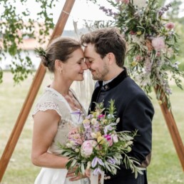Traubogen mit Blumendekoration von Ganz Unverblümt und Brautpaar mit natürlichem Brautstrauß