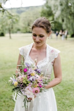 Braut in Tracht mit rustikalem Brautstrauß aus Wiesenblumen von Hochzeitsflorist Ganz Unverblümt