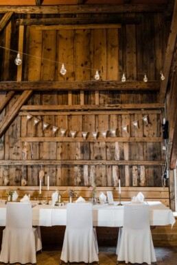 Rustikale Hochzeitslocation mit Lichterketten und Wimpelgirlanden im Bayerischen Wald dekoriert von Ganz Unverblümt