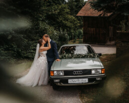 Brautpaar mit Hochzeitsauto dekoriert von Ganz Unverblümt Steinach
