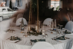Tischdekoration mit Metallständern und viel Grün von Hochzeitsflorist Ganz Unverblümt Steinach
