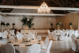Tischdekoration aus Metallständern dekoriert mit viel Grün und Windlichtern von Hochzeitsflorist Ganz Unverblümt