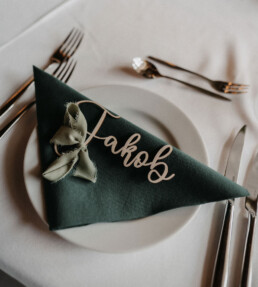 Grüne Stoffserviette und Namensschild mit Schleife als Hochzeitsdekoration in Niederbayern