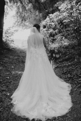 Braut im Brautkleid mit Schleppe von hinten fotografiert