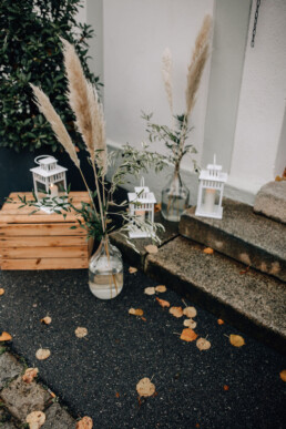 Dekoration aus Laternen, Holzkisten, Vasen und Pampasgras von Hochzeitsflorist Ganz Unverblümt Steinach