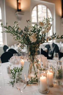 Vasenfüllung mit Grün und weißen Blumen und Windlichter als Tischdekoration von Ganz Unverblümt Steinach