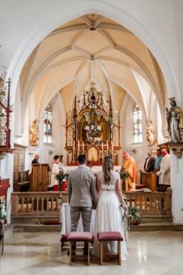 Brautpaar bei der Trauung in der Kirche dekoriert von Ganz Unverblümt